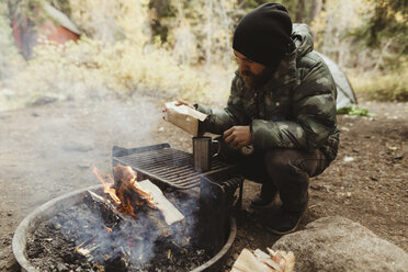 Männlicher Wanderer bei der Zubereitung von Kaffee am Lagerfeuer, Mineral King, Sequoia National Park, Kalifornien, USA - ISF07478
