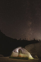Male hiker looking out through tent at night sky, Mineral King, Sequoia National Park, California, USA - ISF07479