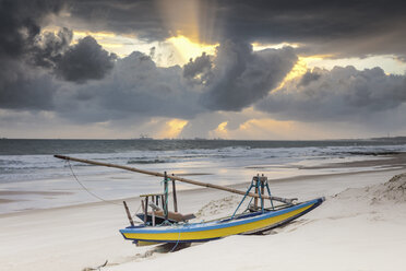 Beached fishing boat and dramatic sky at sunset, Taiba, Ceara, Brazil - ISF07481