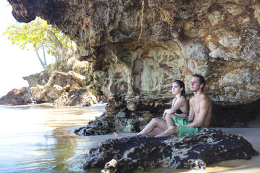 Junges Paar schaut aus einer Strandhöhle, Taiba, Ceara, Brasilien - ISF07484