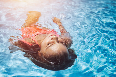 Auf dem Rücken schwimmendes Mädchen im sonnenbeschienenen Schwimmbad - ISF07509