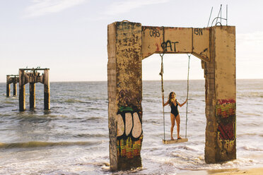 Woman standing on swing, Old Davenport Pier, Santa Cruz, California, USA - ISF07528