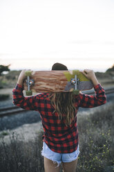 Frau mit Skateboard auf den Schultern - ISF07529