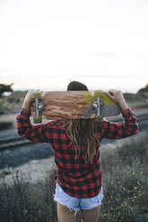 Woman with skateboard on shoulders - ISF07529