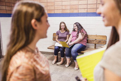 Teenager-Gymnasiastinnen unterhalten sich im Korridor - ISF07539