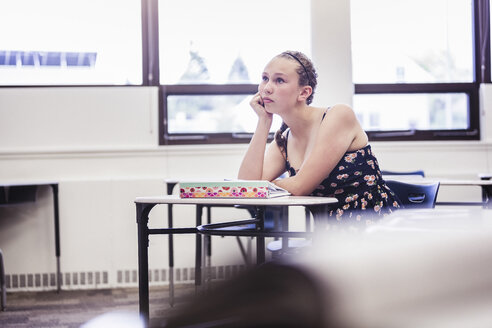 Genervtes Teenager-Mädchen sitzt allein im Klassenzimmer - ISF07540