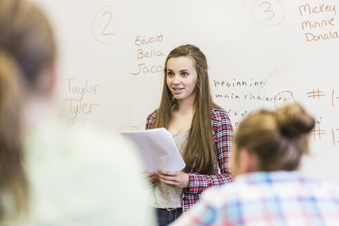 Teenager-Mädchen, das vor einer Tafel im Unterricht der High School liest - ISF07565