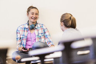 Zwei Teenager-Mädchen plaudern und lachen in der Pause einer Highschool-Klasse - ISF07570