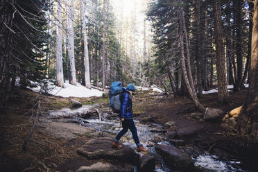 Woman hiking over steam, Yosemite National Park, California, USA - ISF07613