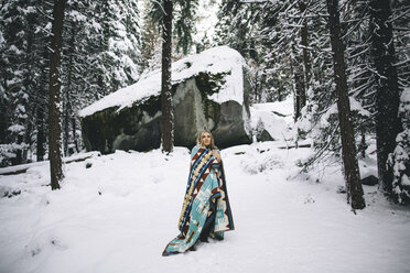 Frau im verschneiten Wald in Decke eingewickelt - ISF07629