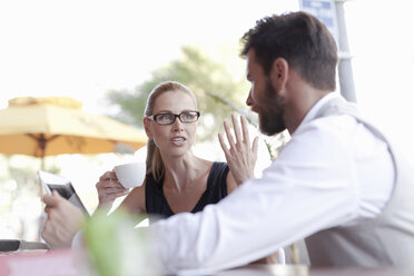 Mature man and woman, sitting outside cafe, having discussion - ISF07663