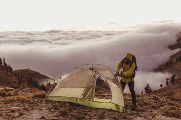 Männlicher Wanderer schlägt sein Zelt über den Wolken auf, Mineral King, Sequoia National Park, Kalifornien, USA - ISF07786