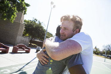 Two male friends congratulating each other after basketball game - ISF07803