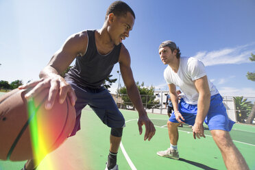 Two male friends playing basketball on outdoor court - ISF07804