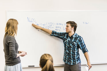 Teenage boy pointing at whiteboard in high school lesson - ISF07865