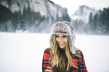 Rear view of woman wearing ushanka hat on snow-covered landscape - ISF07891