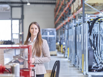 Junge Frau benutzt Tablet in einer Industriehalle - CVF00651