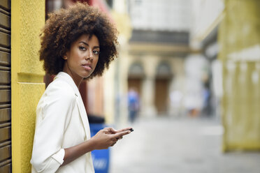 Portrait of waiting young woman with cell phone - JSMF00229