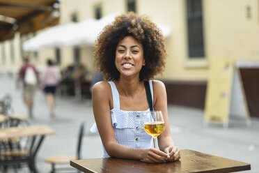 Porträt einer glücklichen jungen Frau beim Biertrinken im Freien - JSMF00270