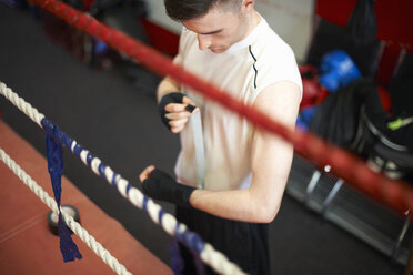 Boxer, der sich vor dem Anziehen der Handschuhe die Hände bandagiert, Ansicht von oben - CUF21411