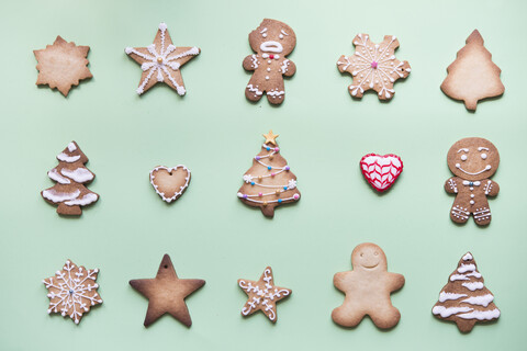 Mit Zuckerguss verzierte Reihen verschiedener Lebkuchen auf hellgrünem Grund, lizenzfreies Stockfoto