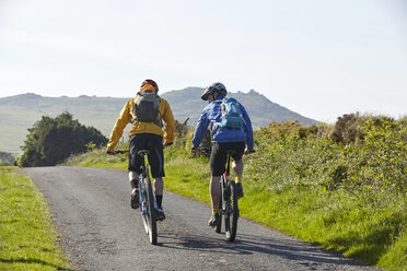 Rear view of cyclists cycling on rural road - CUF21528