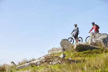 Radfahrer auf Fahrrädern auf einem Felsvorsprung, die wegschauen - CUF21560