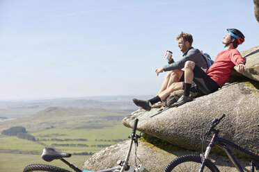 Cyclists resting on rocky outcrop - CUF21565