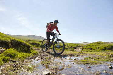 Cyclists cycling through water - CUF21587