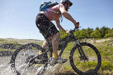 Radfahrer, die durchs Wasser fahren - CUF21590