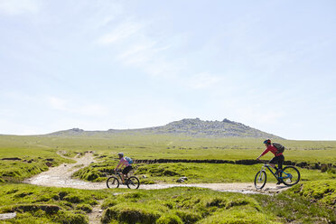 Cyclists cycling on hillside path - CUF21593
