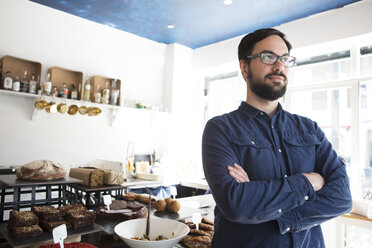Porträt eines erwachsenen männlichen Café-Besitzers am Küchentresen - CUF21625