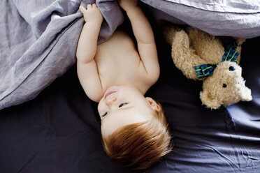 Draufsicht auf ein kleines Mädchen und einen Teddybären, die im Bett liegen - CUF21716
