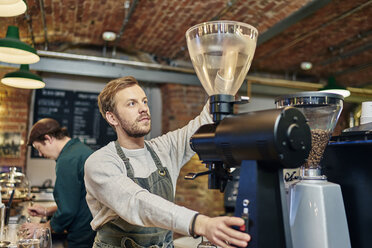 Männlicher Barista mit Kaffeemaschine an der Küchentheke eines Cafés - CUF21795