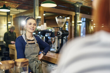 Female barista serving customer in coffee shop - CUF21808