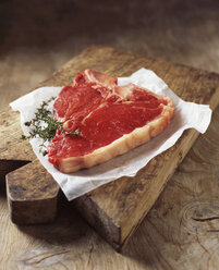 Food, meat, beef, t-bone steak, on rustic wooden chopping board - CUF21881