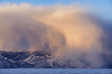 Tief hängende Gewitterwolken über schneebedeckten Bergen, Baikalsee, Insel Olchon, Sibirien, Russland - CUF22069