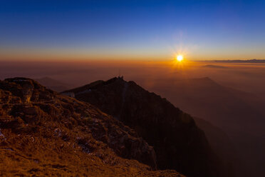 Elevated silhouetted landscape with valley mist at sunset, Monte Generoso,Ticino, Switzerland - CUF22140