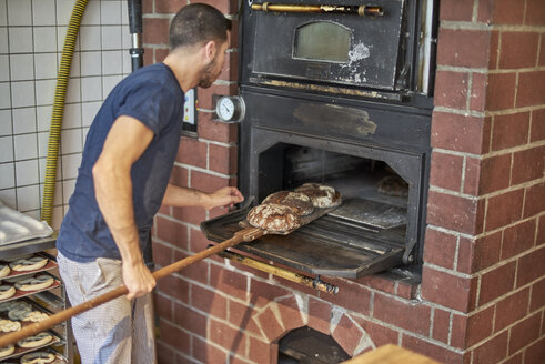 Bäcker backt frisches Bio-Brot aus dem Ofen - BEF00118