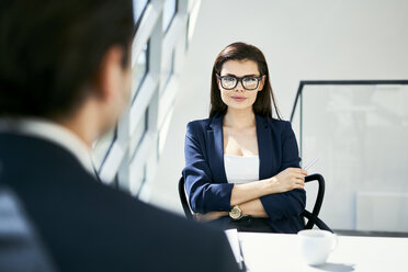 Porträt einer selbstbewussten Geschäftsfrau mit Geschäftsmann in einem modernen Büro - BSZF00460