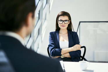 Portrait of confident businesswoman with businessman in modern office - BSZF00460