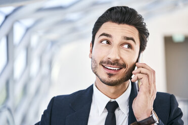 Portait of smiling businessman on cell phone - BSZF00506