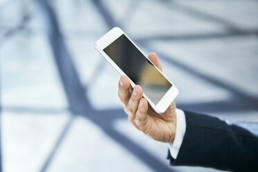 Close-up of businessman holding cell phone - BSZF00510
