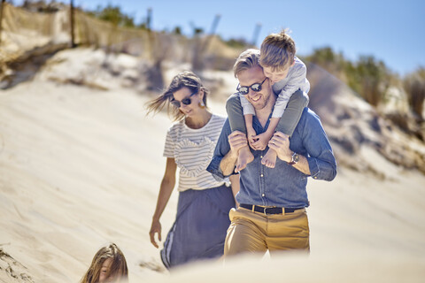 Glückliche Familie beim gemeinsamen Spaziergang am Strand, lizenzfreies Stockfoto