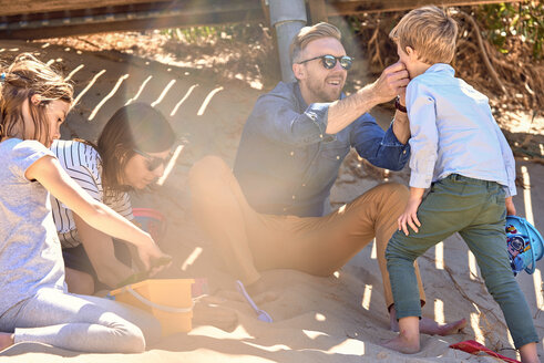 Familie spielt im Schatten am Strand - BEF00127