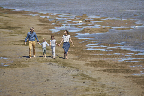 Australia, Adelaide, Onkaparinga River, happy family walking together hands in hands at beach stock photo