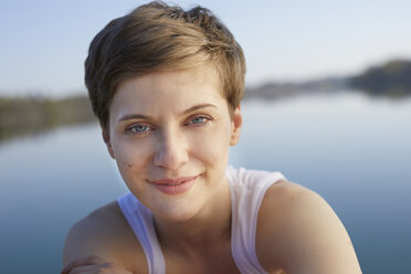 Porträt einer lächelnden Frau vor einem See - PNEF00659