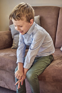 Glücklicher Junge auf der Couch sitzend - BEF00140