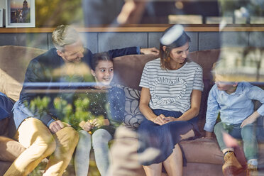 Glückliche Familie, die sich zu Hause auf der Couch entspannt - BEF00143