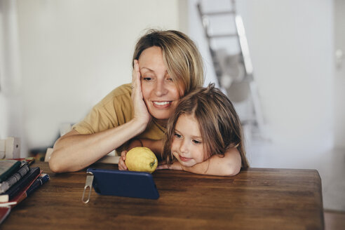 Mutter und kleine Tochter benutzen Smartphone im neuen Zuhause - KMKF00255